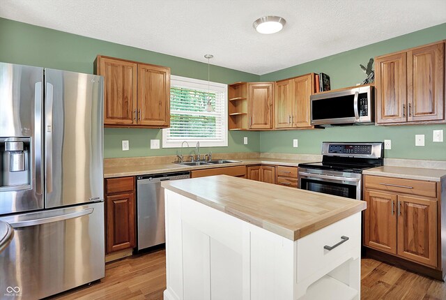 1697 Stacy Lynn Dr, Indianapolis, IN 46231 - kitchen with stainless steel appliances, open shelves, a sink, light wood-type flooring, and butcher block counters