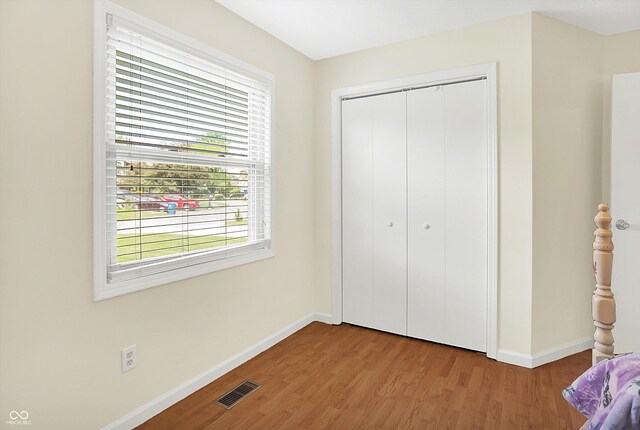 1697 Stacy Lynn Dr, Indianapolis, IN 46231 - unfurnished bedroom with baseboards, wood finished floors, and multiple windows