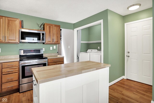 1697 Stacy Lynn Dr, Indianapolis, IN 46231 - kitchen with stainless steel appliances, independent washer and dryer, butcher block counters, light wood-style floors, and a textured ceiling