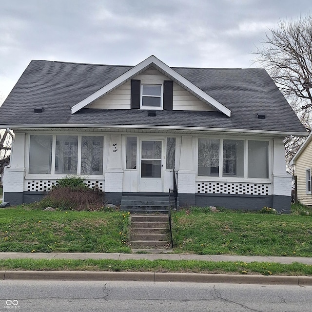 bungalow with roof with shingles, a front yard, and entry steps
