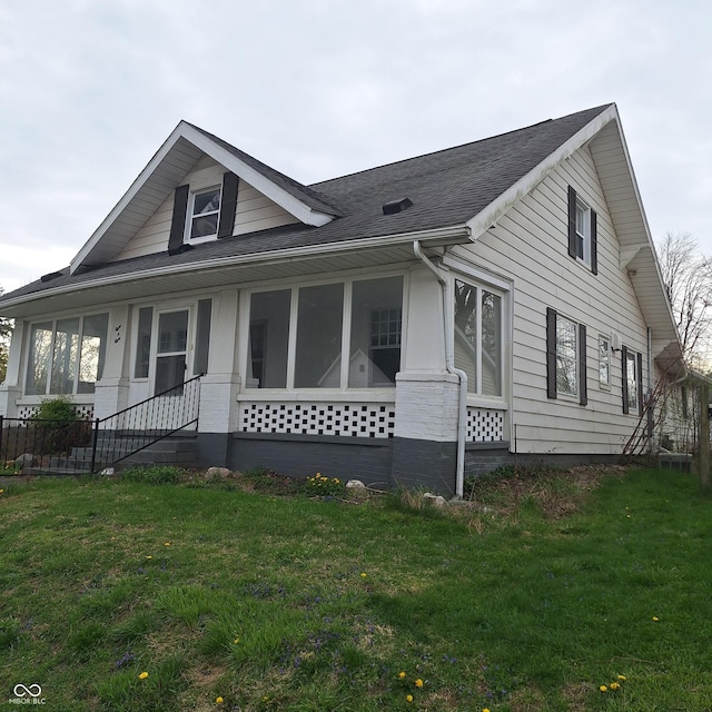 view of front of property featuring roof with shingles and a front lawn