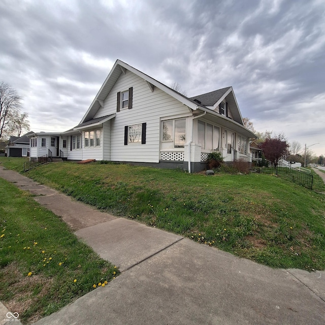 view of property exterior featuring fence and a lawn