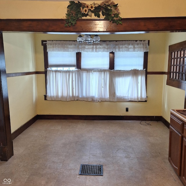 empty room featuring baseboards and visible vents