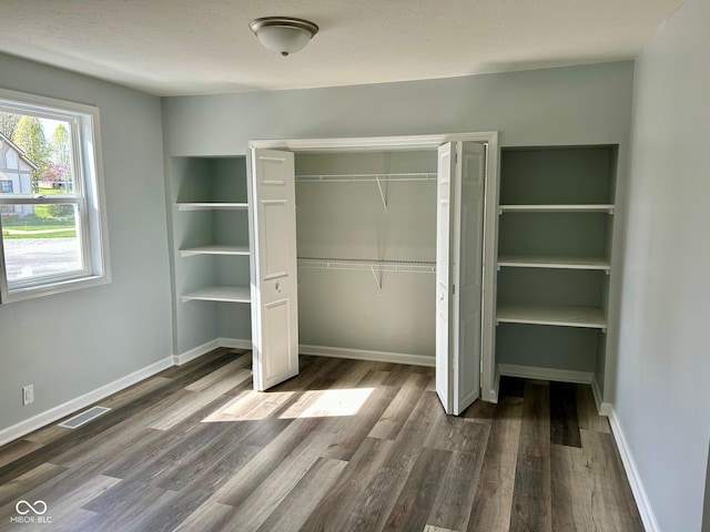 103 N Nebraska St, North Salem, IN 46165 - unfurnished bedroom with baseboards, wood finished floors, visible vents, and a closet
