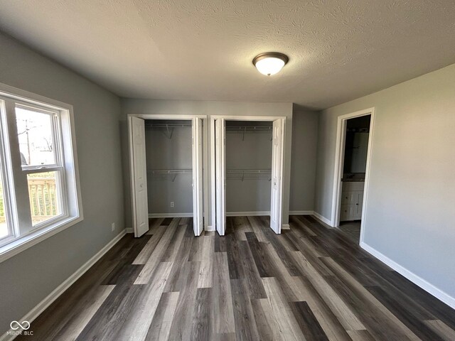 103 N Nebraska St, North Salem, IN 46165 - unfurnished bedroom featuring baseboards, two closets, and dark wood-style floors