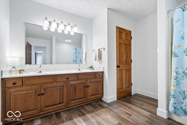 244 W Admiral Way S, Carmel, IN 46032 - bathroom with double vanity, wood finished floors, a textured ceiling, baseboards, and a shower with shower curtain