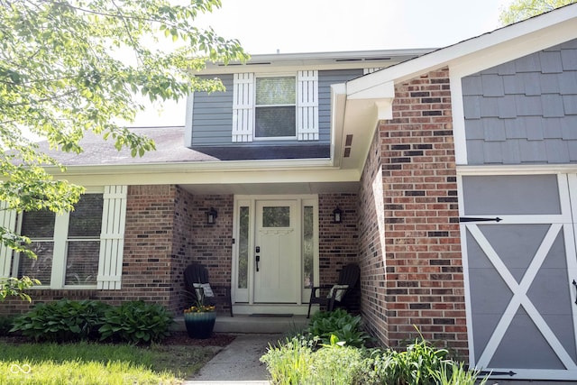 view of exterior entry featuring brick siding