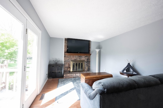 living room with light wood-style floors and a brick fireplace