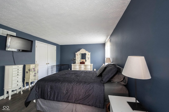 bedroom with visible vents, a closet, a textured ceiling, and wood finished floors