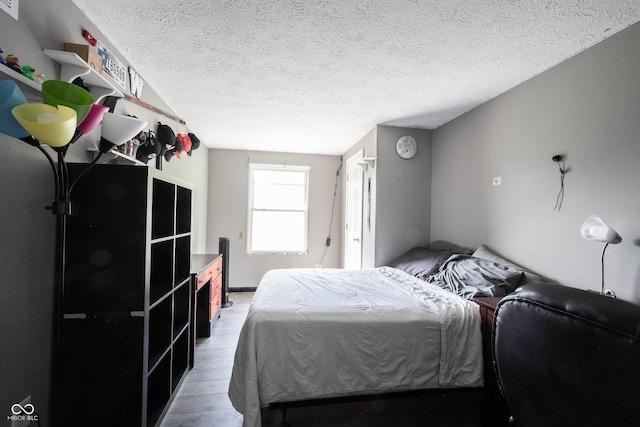 bedroom featuring a textured ceiling and light wood finished floors