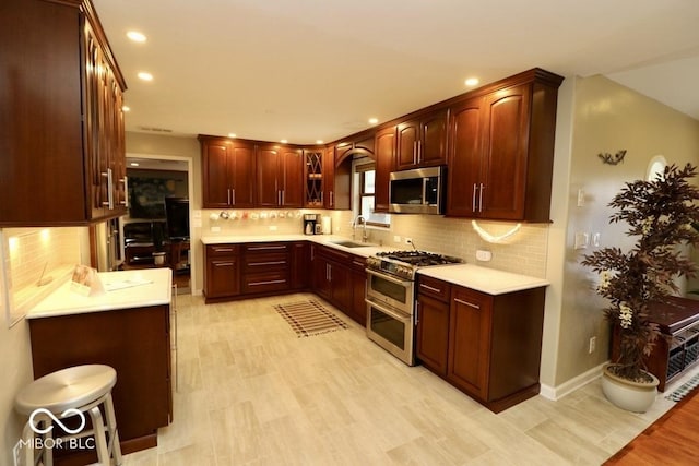 kitchen featuring light countertops, appliances with stainless steel finishes, recessed lighting, and a sink