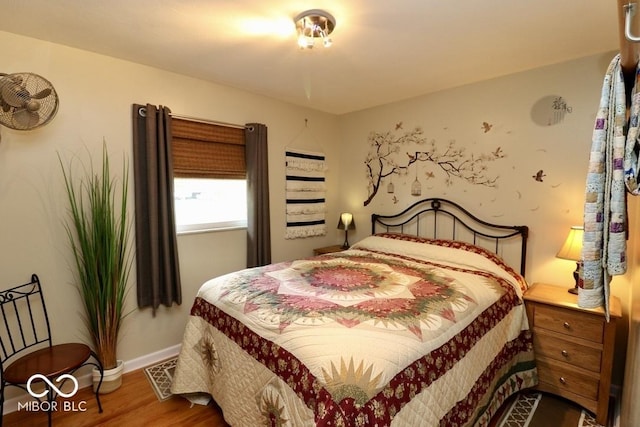 bedroom featuring visible vents, baseboards, and wood finished floors