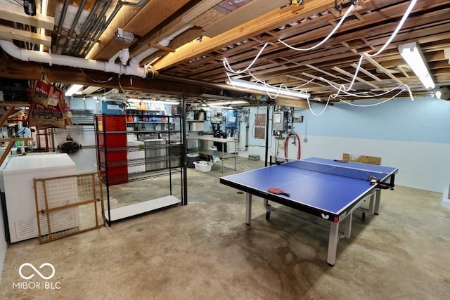 playroom featuring concrete block wall and unfinished concrete floors