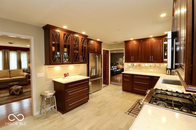 kitchen with light countertops, backsplash, stainless steel appliances, and recessed lighting