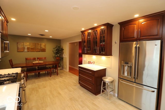 kitchen with stainless steel appliances, recessed lighting, and glass insert cabinets