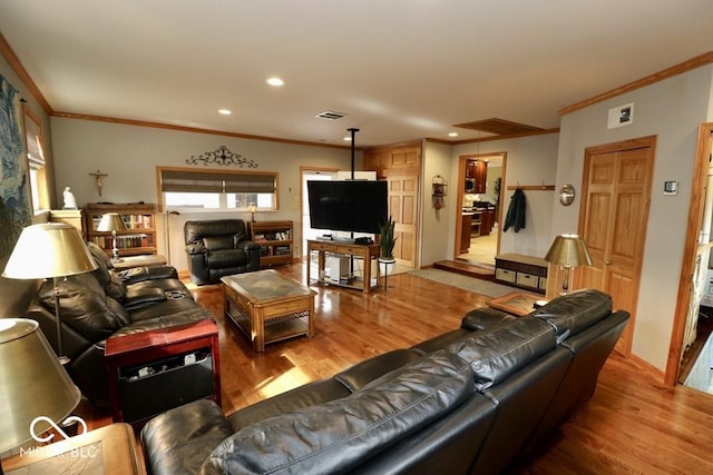 living room with ornamental molding, wood finished floors, visible vents, and recessed lighting