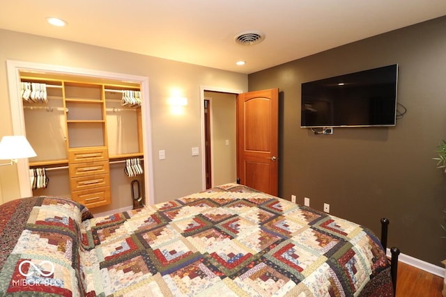 bedroom with recessed lighting, a closet, wood finished floors, and visible vents