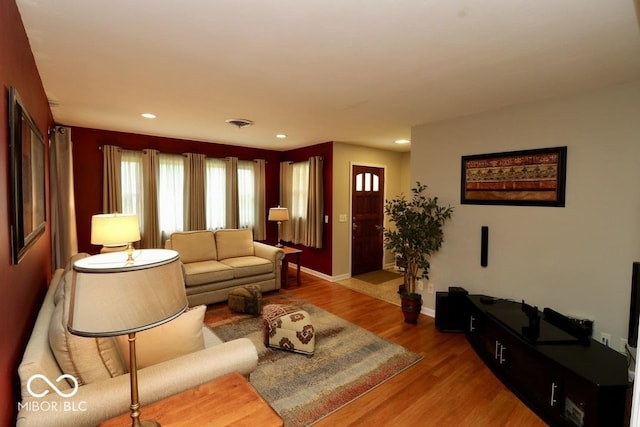 living room featuring recessed lighting, wood finished floors, visible vents, and plenty of natural light
