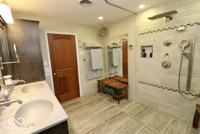 full bathroom featuring double vanity, walk in shower, visible vents, and a sink