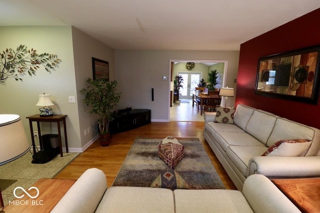 living area with baseboards and wood finished floors