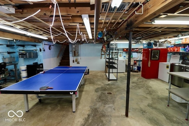recreation room featuring unfinished concrete floors and independent washer and dryer