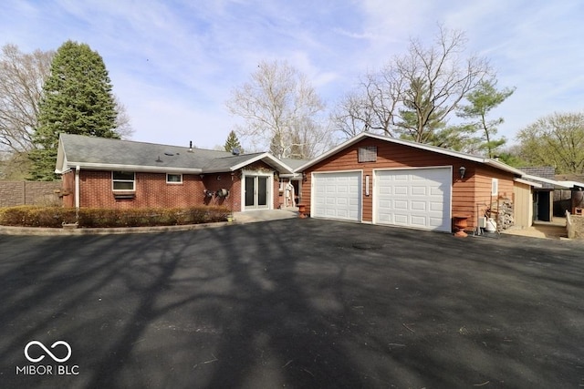 ranch-style house featuring a garage, driveway, and brick siding