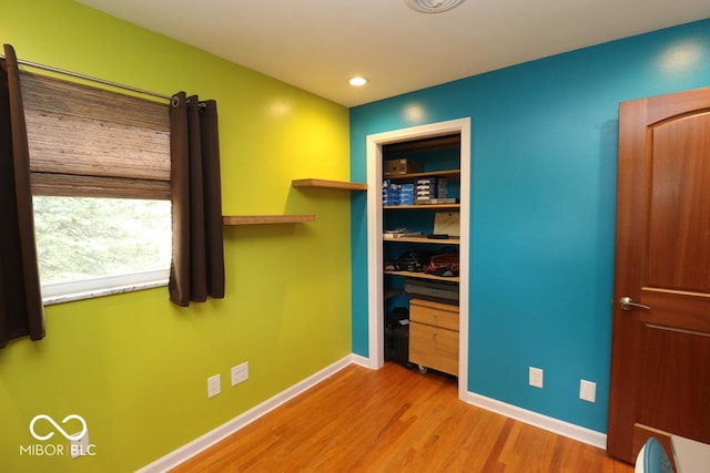 interior space featuring recessed lighting, wood finished floors, a closet, and baseboards