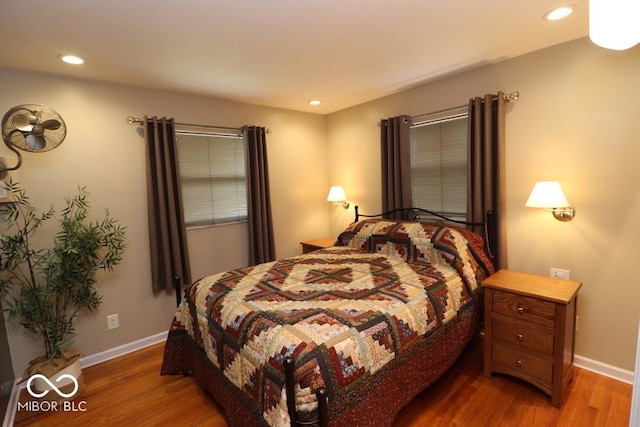bedroom with recessed lighting, wood finished floors, and baseboards