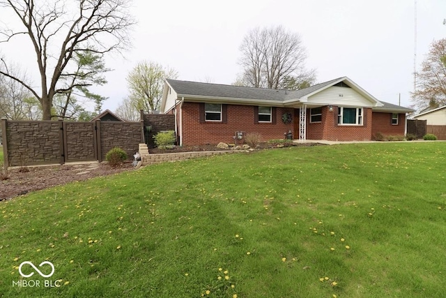 ranch-style house with brick siding, a front lawn, and fence