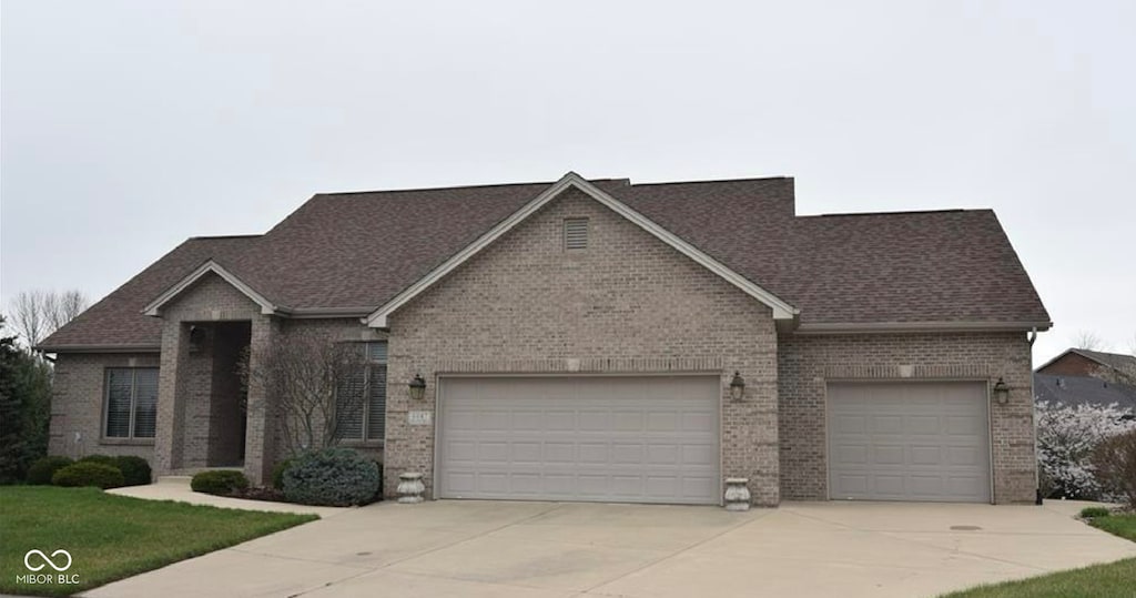 6087 Boulder Ct, Columbus, IN 47201 - view of front facade with concrete driveway, a garage, a shingled roof, and brick siding