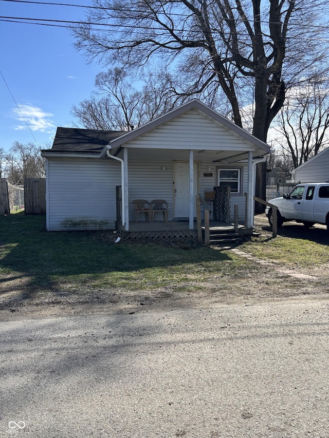 garage featuring fence and a porch