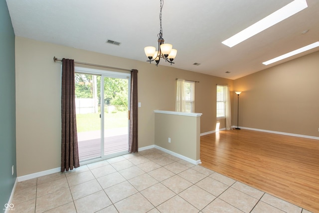 1579 Winding Creek Trl, Brownsburg, IN 46112 - spare room with healthy amount of natural light, a chandelier, a skylight, and light wood-type flooring