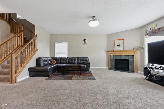 621 Fireside Dr, Greenwood, IN 46143 - carpeted living area featuring stairway, a tile fireplace, baseboards, and a textured ceiling