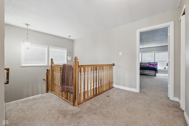 621 Fireside Dr, Greenwood, IN 46143 - hallway with carpet, an upstairs landing, a textured ceiling, and baseboards