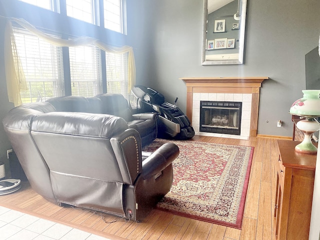 living room featuring wood-type flooring and a tile fireplace