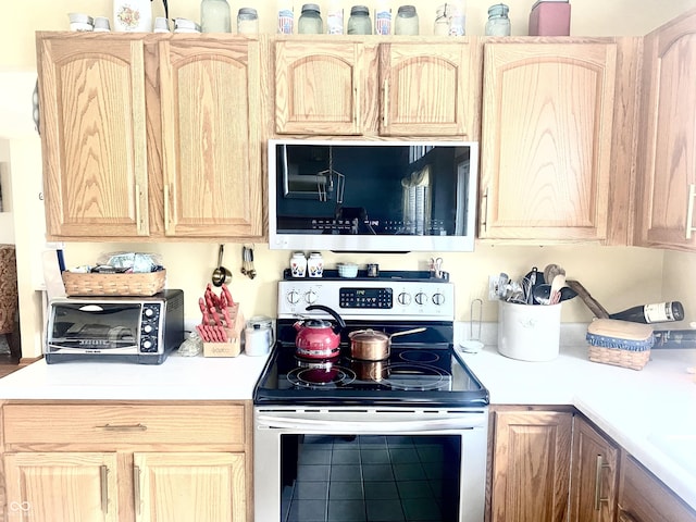 kitchen with stainless steel appliances, light countertops, and light brown cabinetry