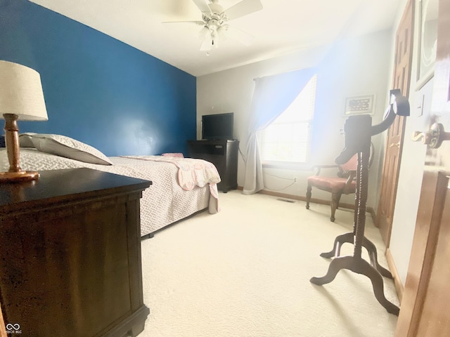 carpeted bedroom with visible vents, baseboards, and ceiling fan