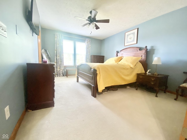 carpeted bedroom featuring baseboards, a textured ceiling, and ceiling fan