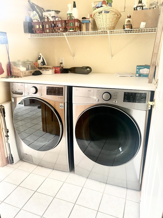 laundry area featuring washer and clothes dryer, laundry area, and light tile patterned floors