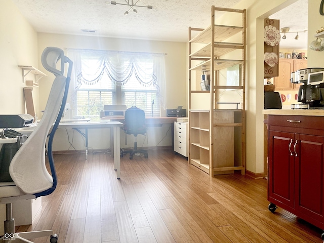 office space featuring visible vents, wood finished floors, and a textured ceiling