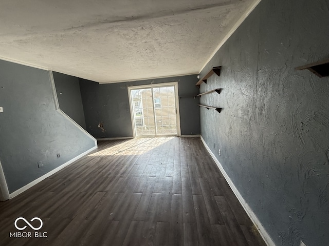 unfurnished living room with baseboards, wood finished floors, and a textured ceiling