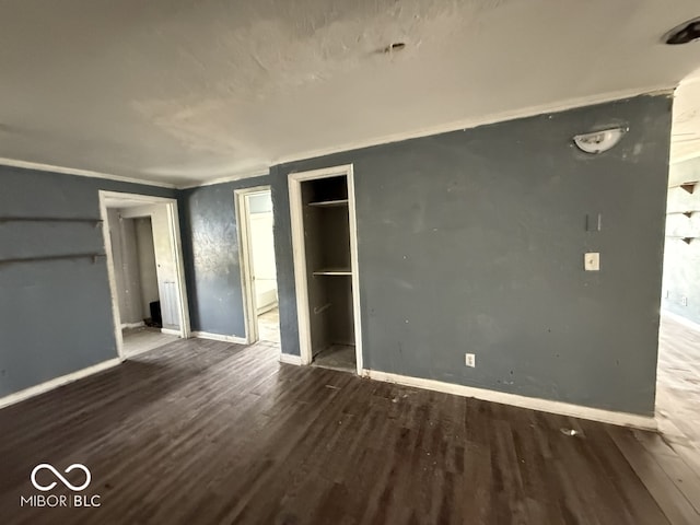 unfurnished bedroom with wood finished floors and baseboards