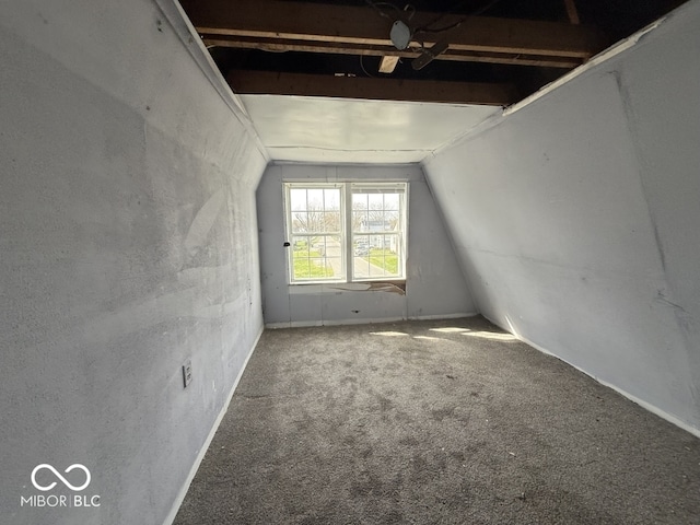 empty room with vaulted ceiling, carpet floors, and baseboards