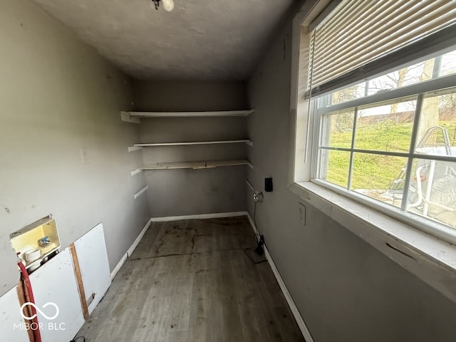 clothes washing area with washer hookup, baseboards, wood finished floors, and laundry area