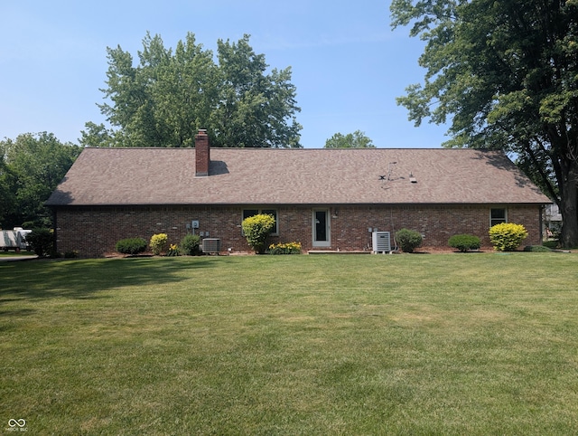 8017 Dogwood Ct, Plainfield, IN 46168 - back of property with a yard, brick siding, a chimney, and a shingled roof