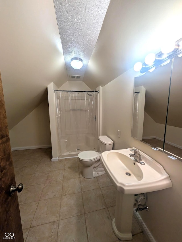 8017 Dogwood Ct, Plainfield, IN 46168 - full bathroom featuring vaulted ceiling, a textured ceiling, a shower stall, and tile patterned flooring