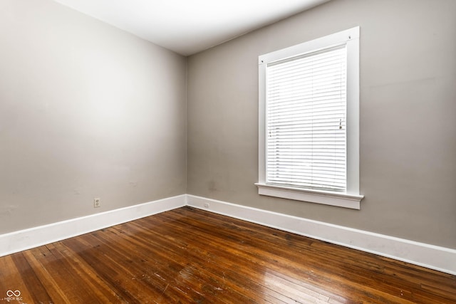 801 N Pennsylvania St Apt D, Indianapolis, IN 46204 - unfurnished room with baseboards and dark wood-type flooring
