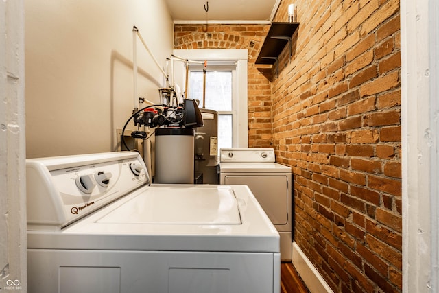 801 N Pennsylvania St Apt D, Indianapolis, IN 46204 - washroom featuring separate washer and dryer and brick wall