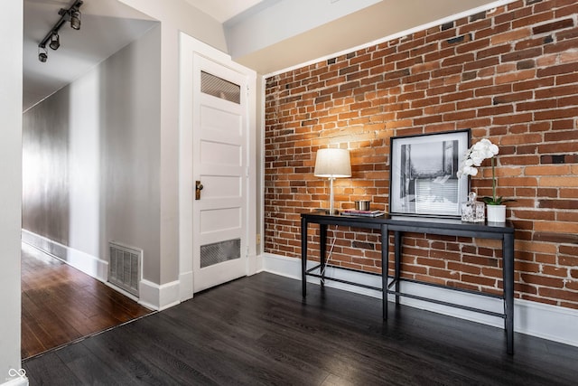 801 N Pennsylvania St Apt D, Indianapolis, IN 46204 - unfurnished office with baseboards, wood finished floors, track lighting, and brick wall
