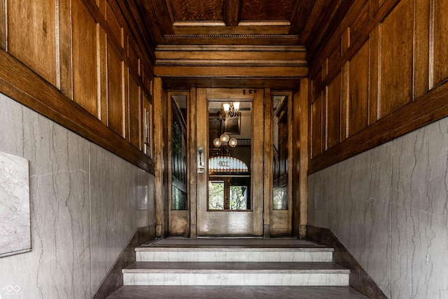 801 N Pennsylvania St Apt D, Indianapolis, IN 46204 - stairway with wooden walls, a chandelier, and crown molding